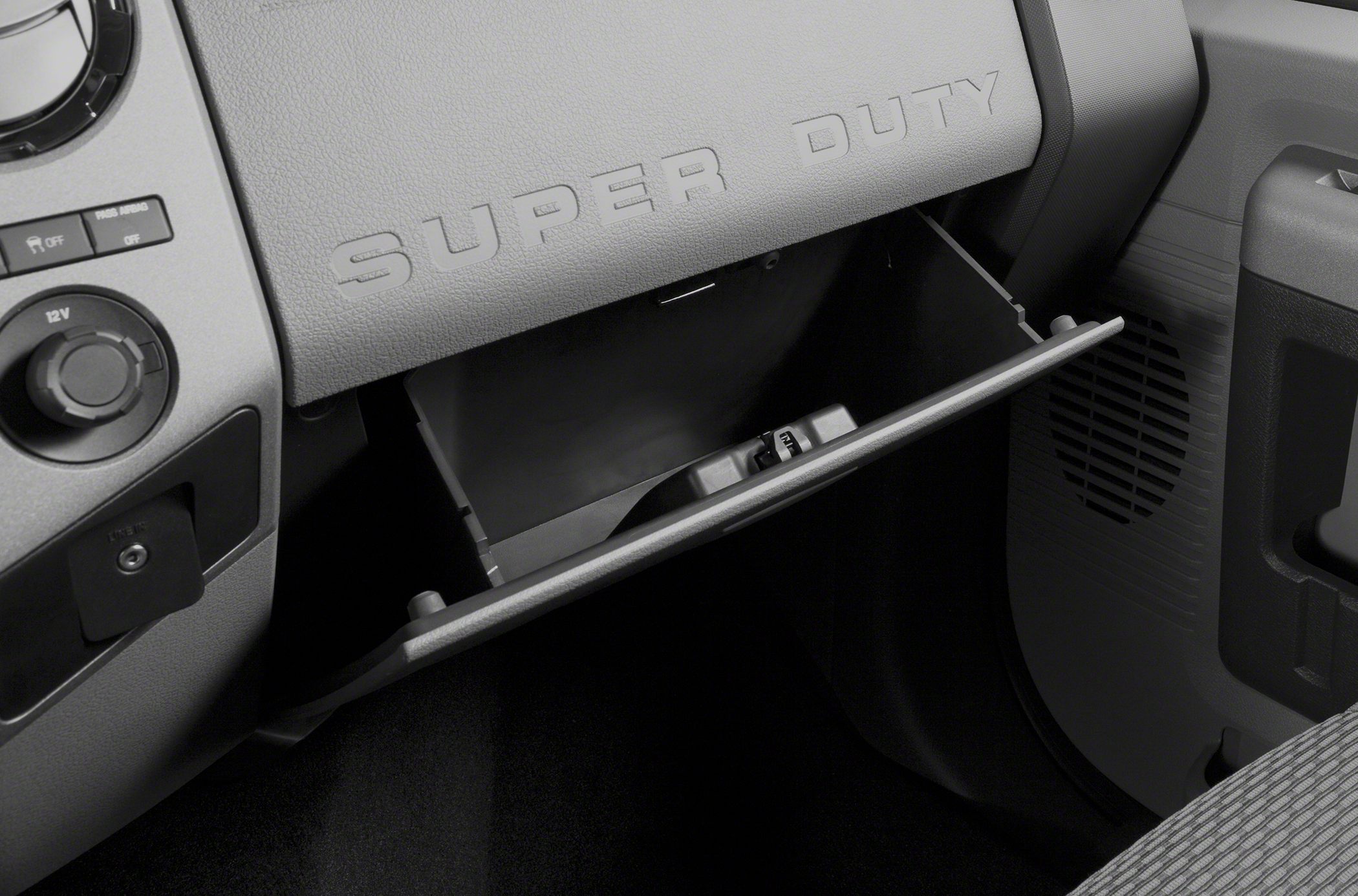 Open glove compartment and dashboard interior with 'SUPER DUTY' embossing