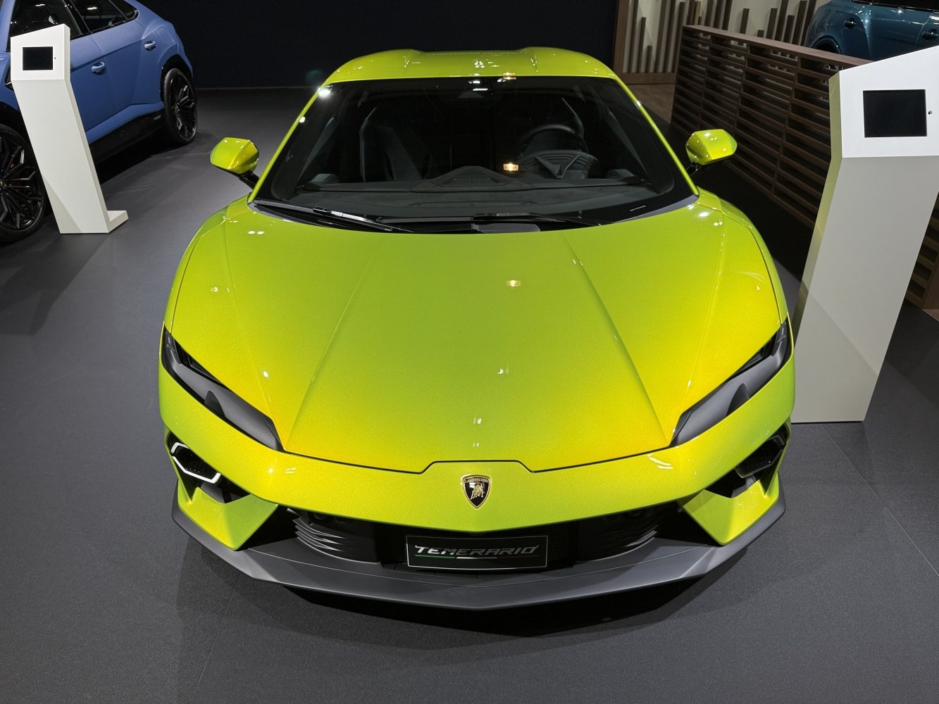 Aerodynamic hood and sharp headlights of a sports car front.