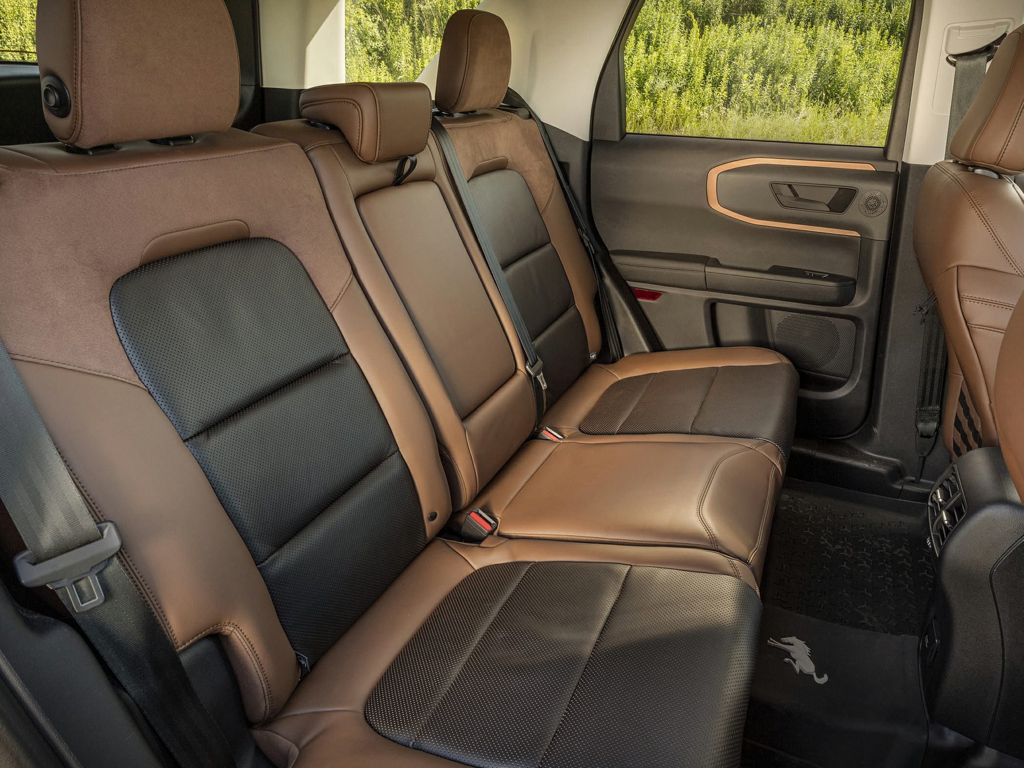 Brown leather rear seats with black inserts and SUV door panel