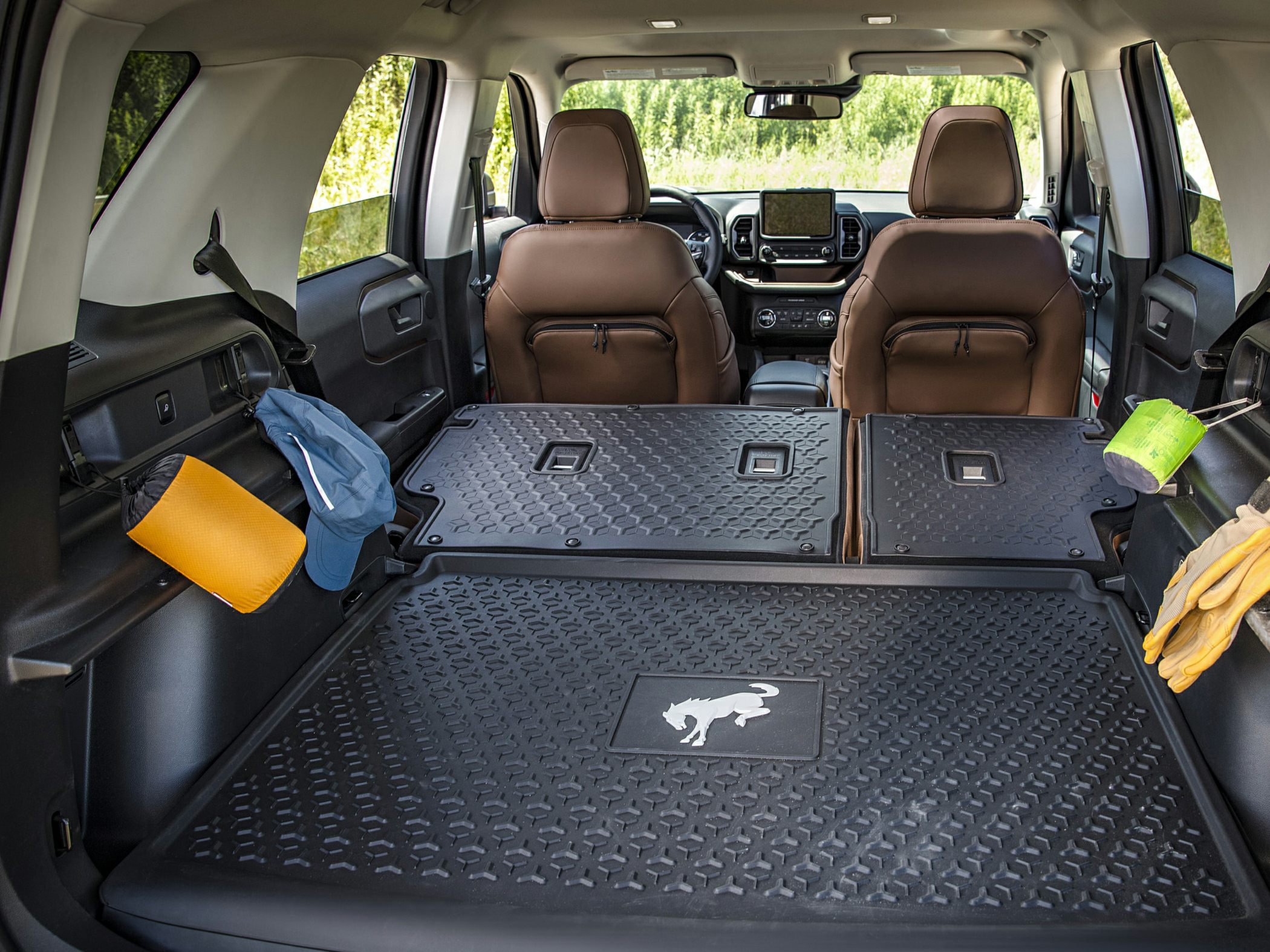 Spacious cargo area with folded rear seats and durable rubber mat featuring Bronco emblem