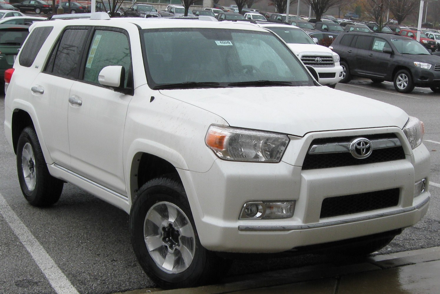 White SUV with bold front grille, alloy wheels, and fog lights