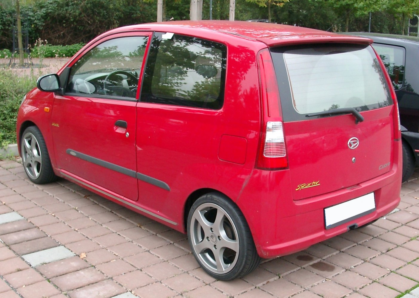 Compact hatchback rear and side view with alloy wheels and roof spoiler