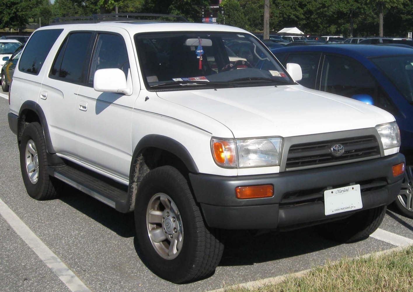 White SUV with roof rails, off-road tires, and rugged front bumper