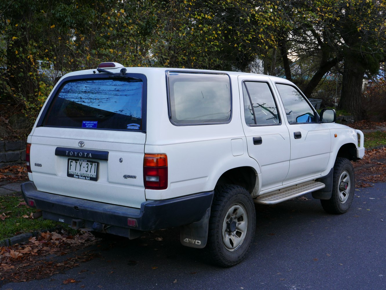 Rear angle of 4WD SUV with off-road tires and side steps