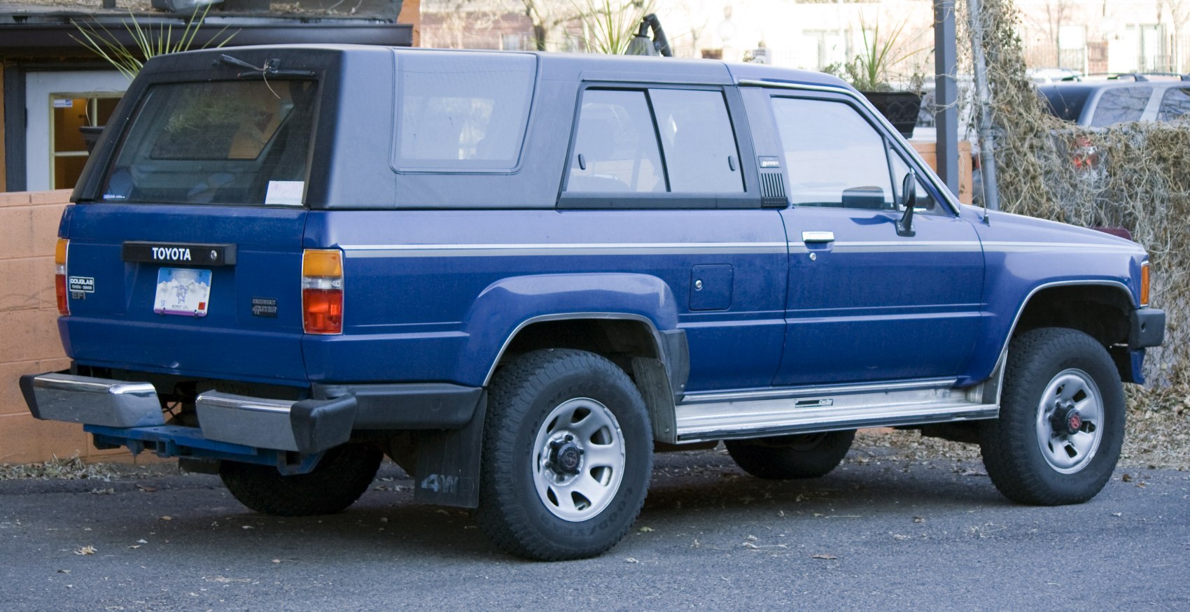 Classic 1980s blue SUV with dual rear bumpers and off-road tires