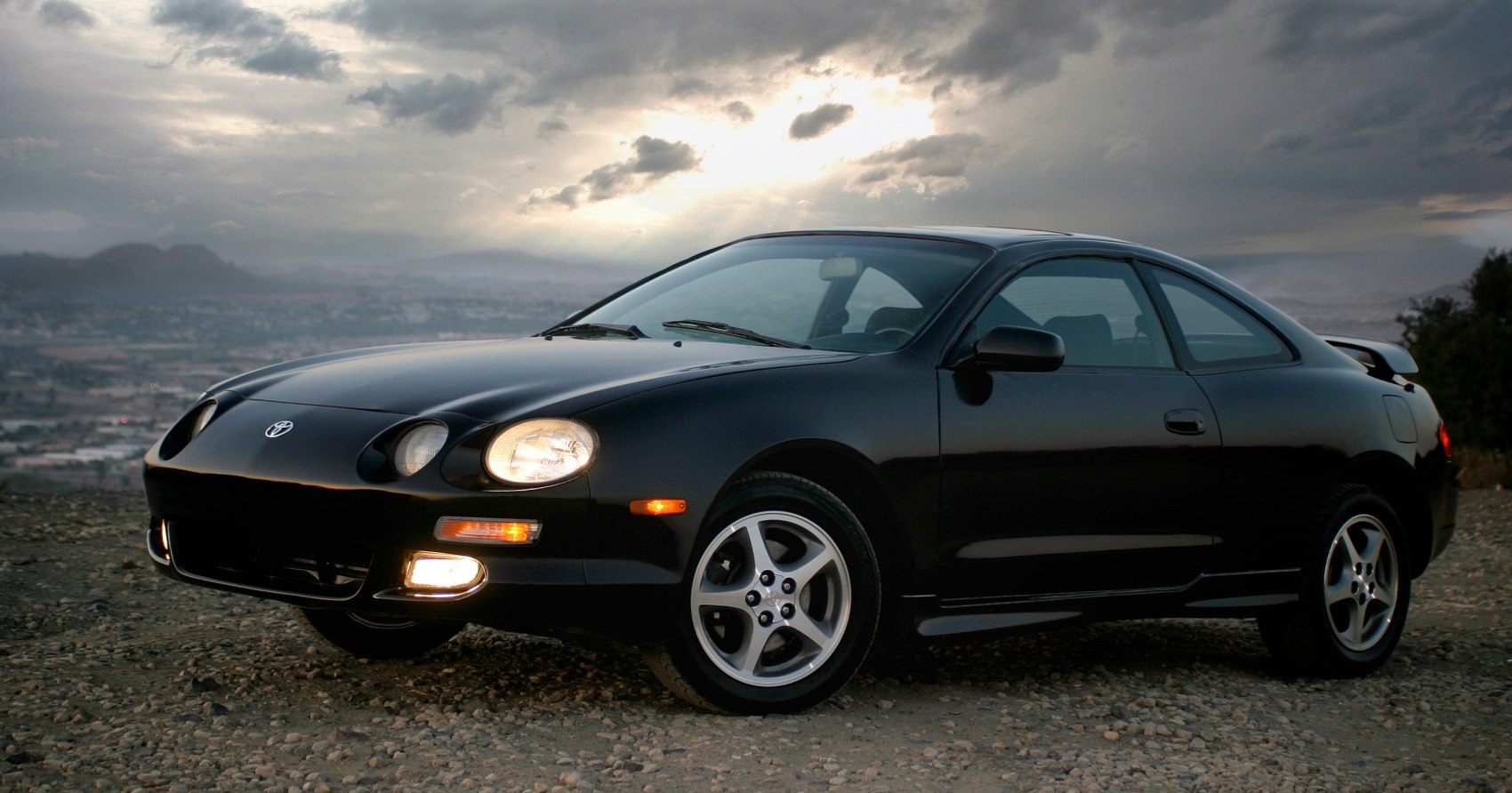 Black coupe with round pop-up headlights and sporty alloy wheels