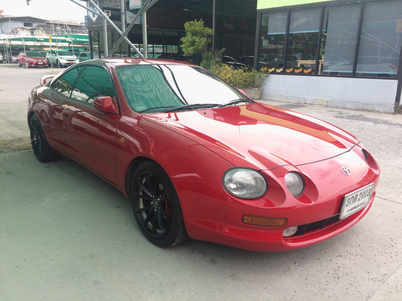 Red coupe with round headlights and black alloy wheels
