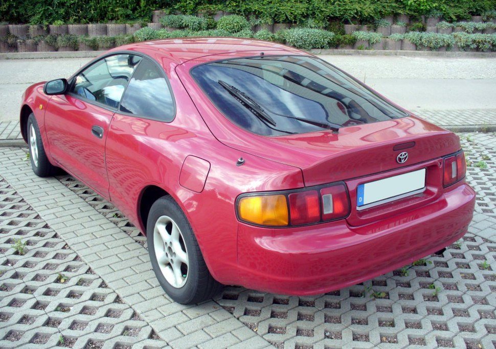 Rear three-quarter view of red sporty coupe with distinctive tail lights.