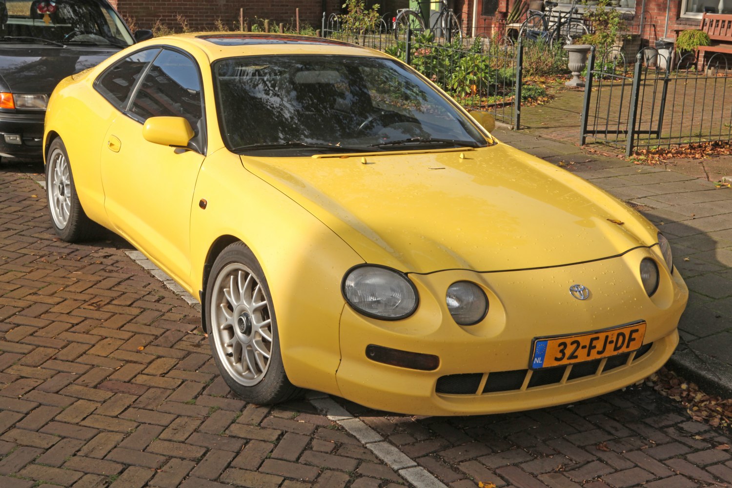 Yellow sports coupe with round headlights and alloy wheels