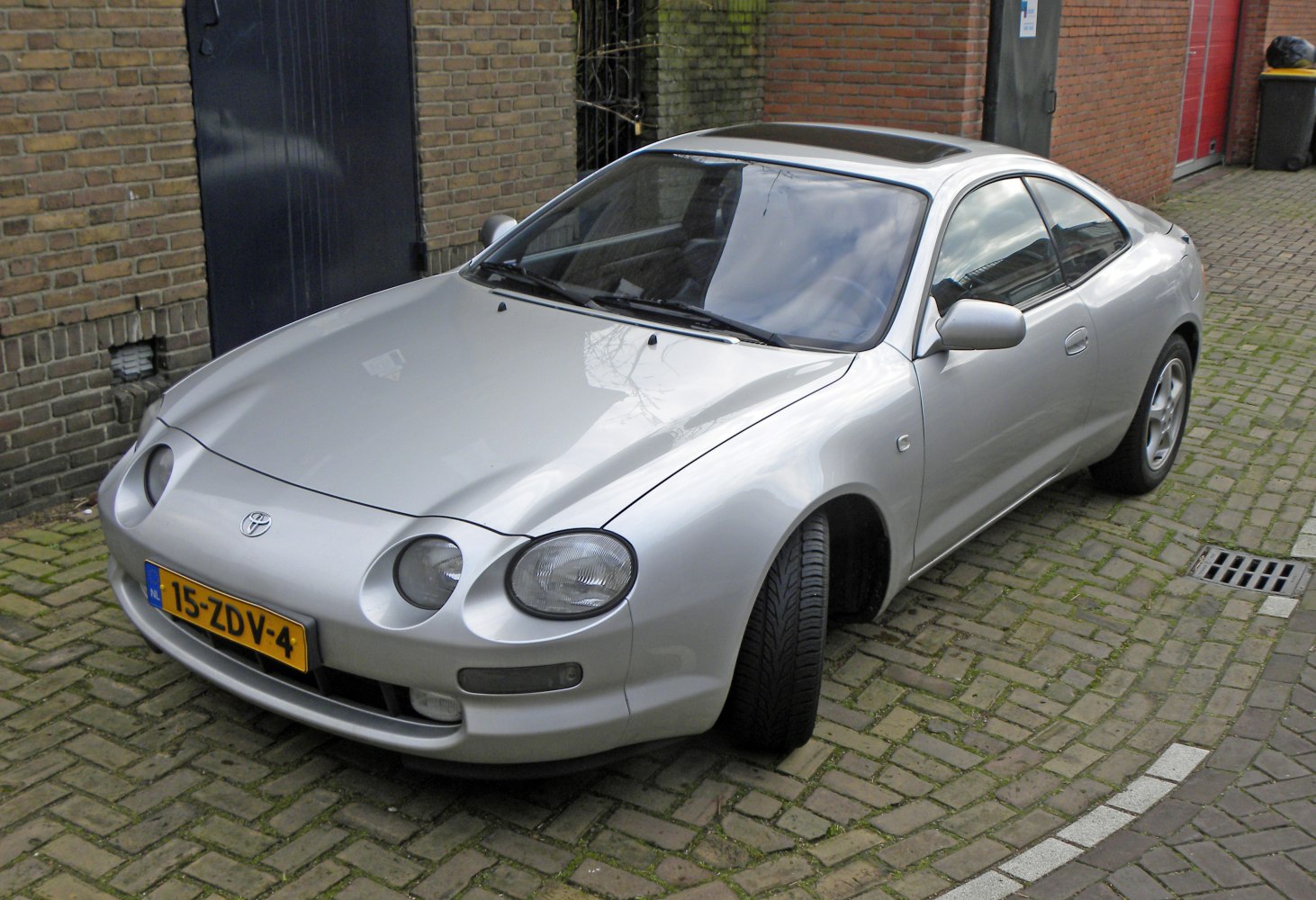 Silver sports coupe with distinctive round headlights and aerodynamic body