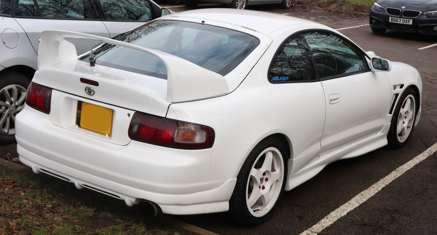 Rear view with GT-Four spoiler, side skirts, and white five-spoke wheels