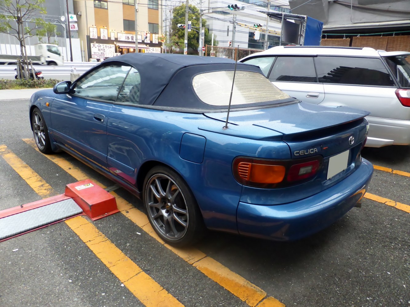 Convertible sports coupe with dark soft top and rear spoiler