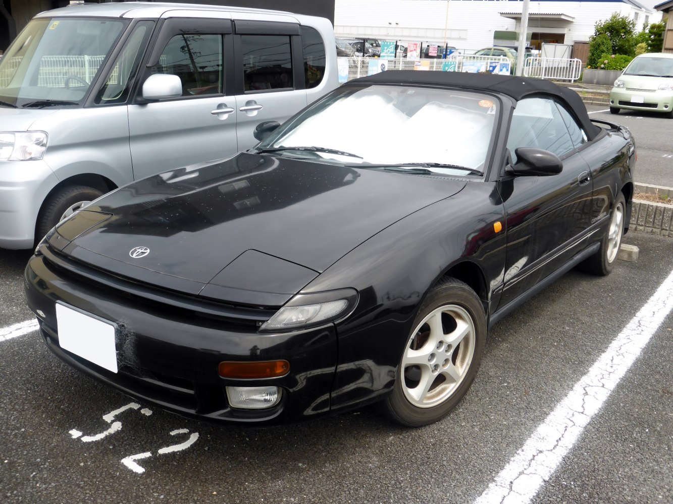 Black convertible sports coupe with pop-up headlights and alloy wheels