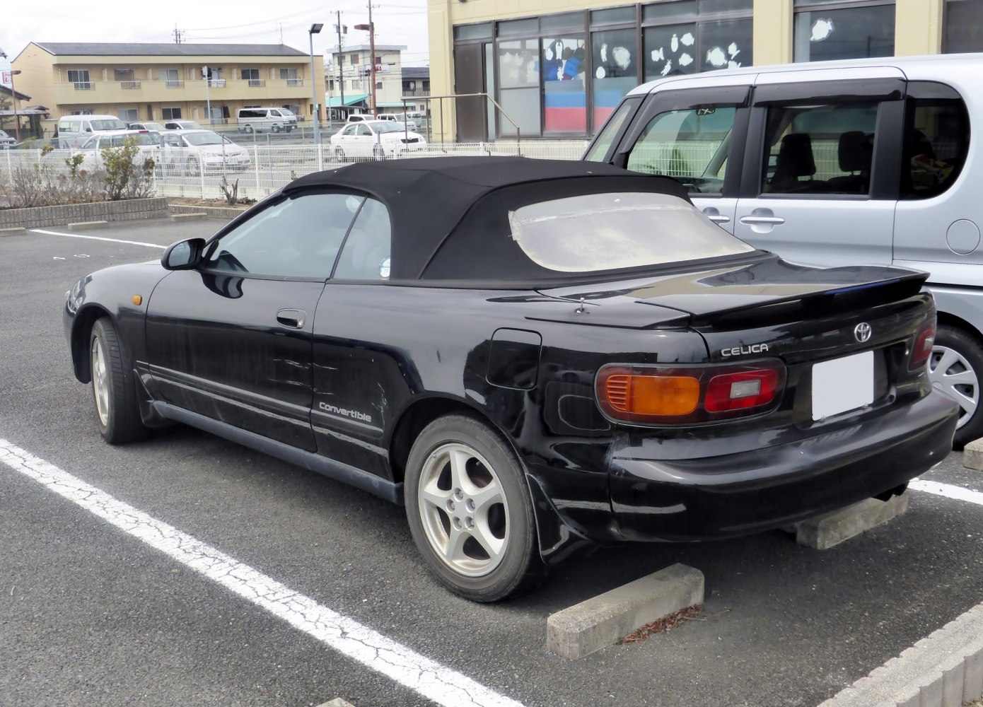 Black convertible sports coupe with soft top and rear spoiler