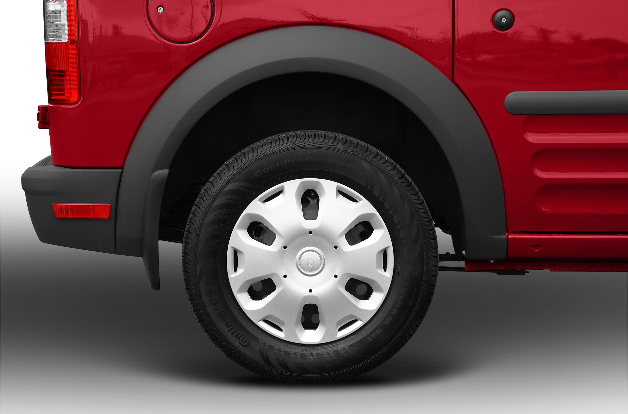 Close-up of a van's wheel, tire, and fender flare in red paint