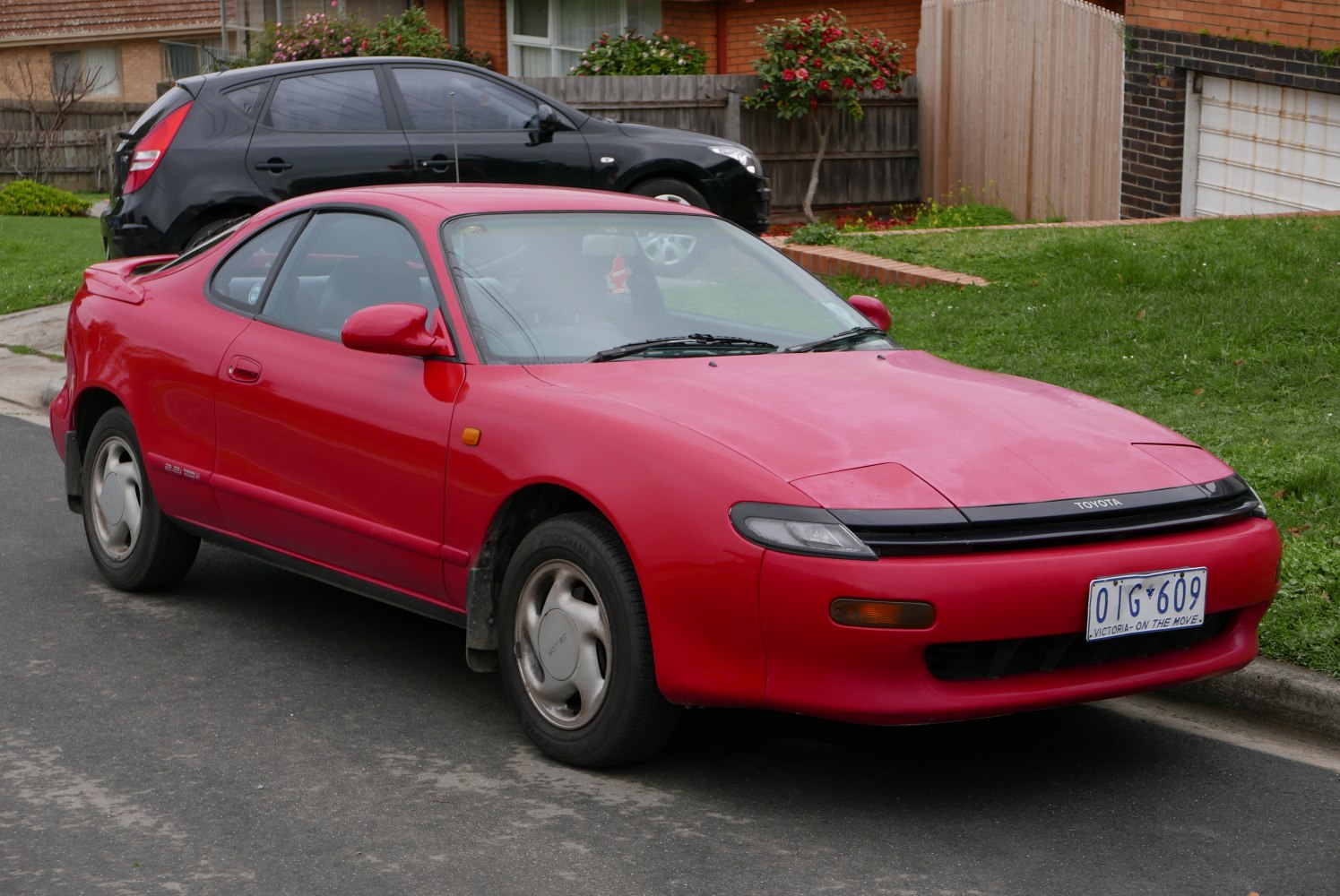 Front side view of red sports coupe with pop-up headlights