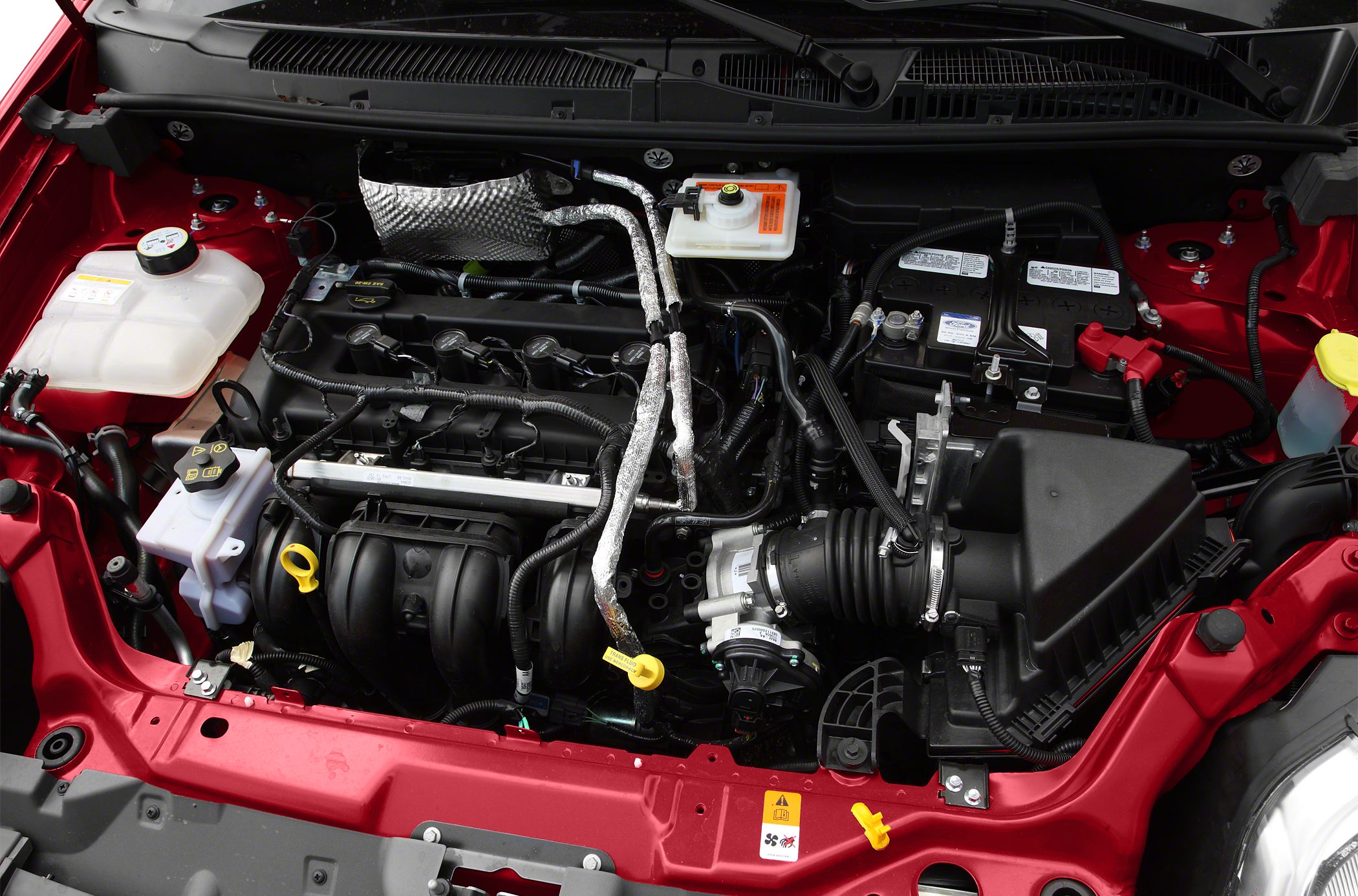 Engine bay with air intake, fluid reservoirs, battery, and wiring layout
