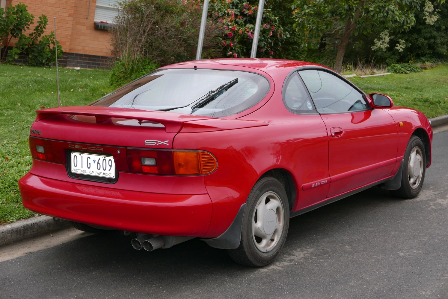 Red coupe with rear spoiler and 2.2L engine badge