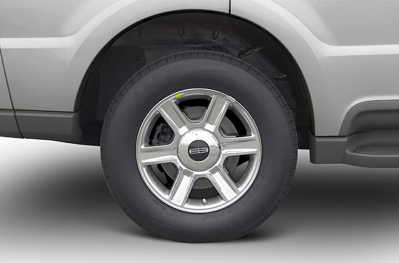 Close-up of steel rim wheel and tire with six-spoke design.