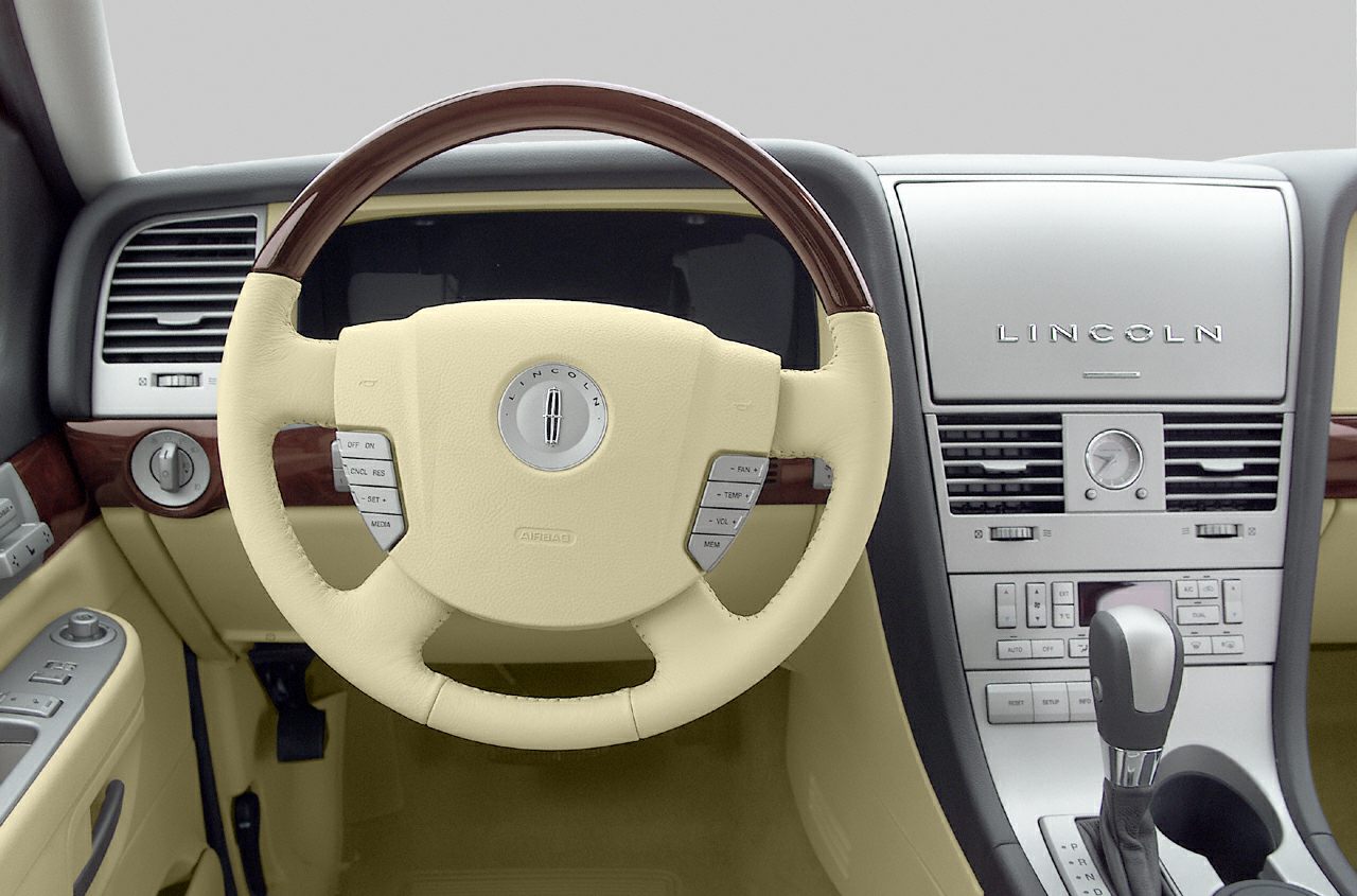 Leather steering wheel with wood trim and detailed dashboard controls