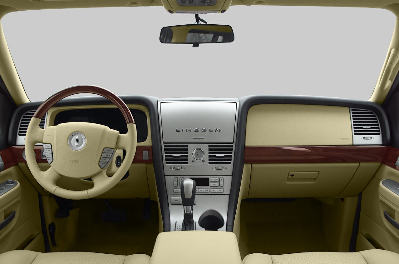 Interior dashboard and steering wheel with wood trim and beige upholstery
