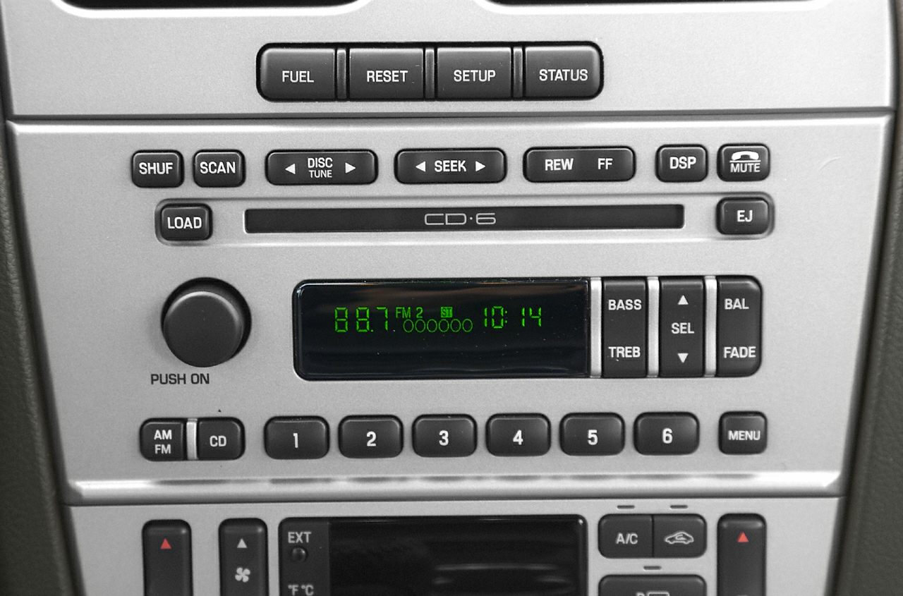 Car stereo and climate control panel with buttons and digital display