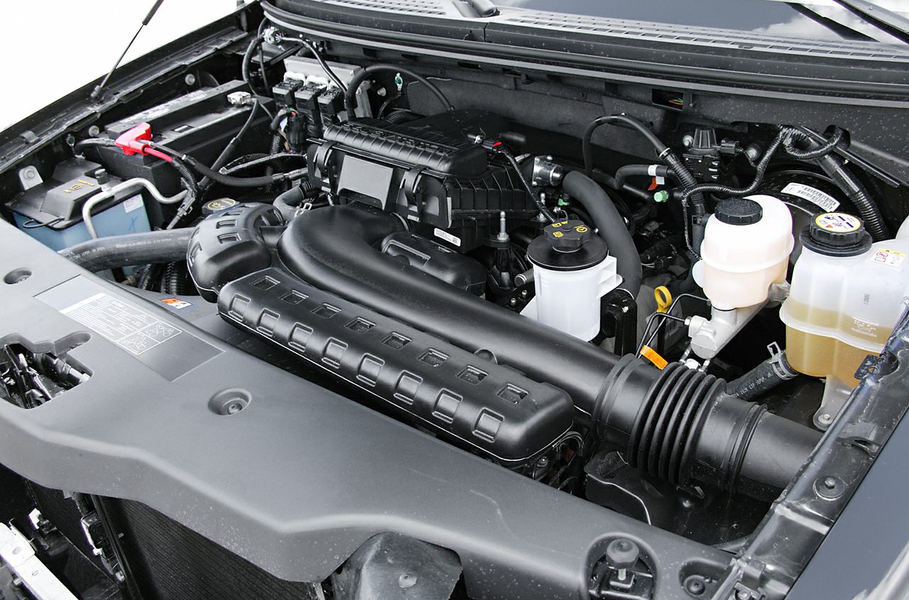 Engine bay intake system and fluid reservoirs with battery terminal