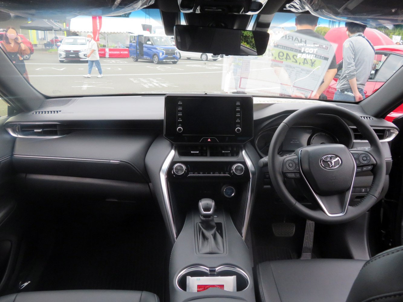 Modern car interior dashboard with center touchscreen and steering wheel controls.