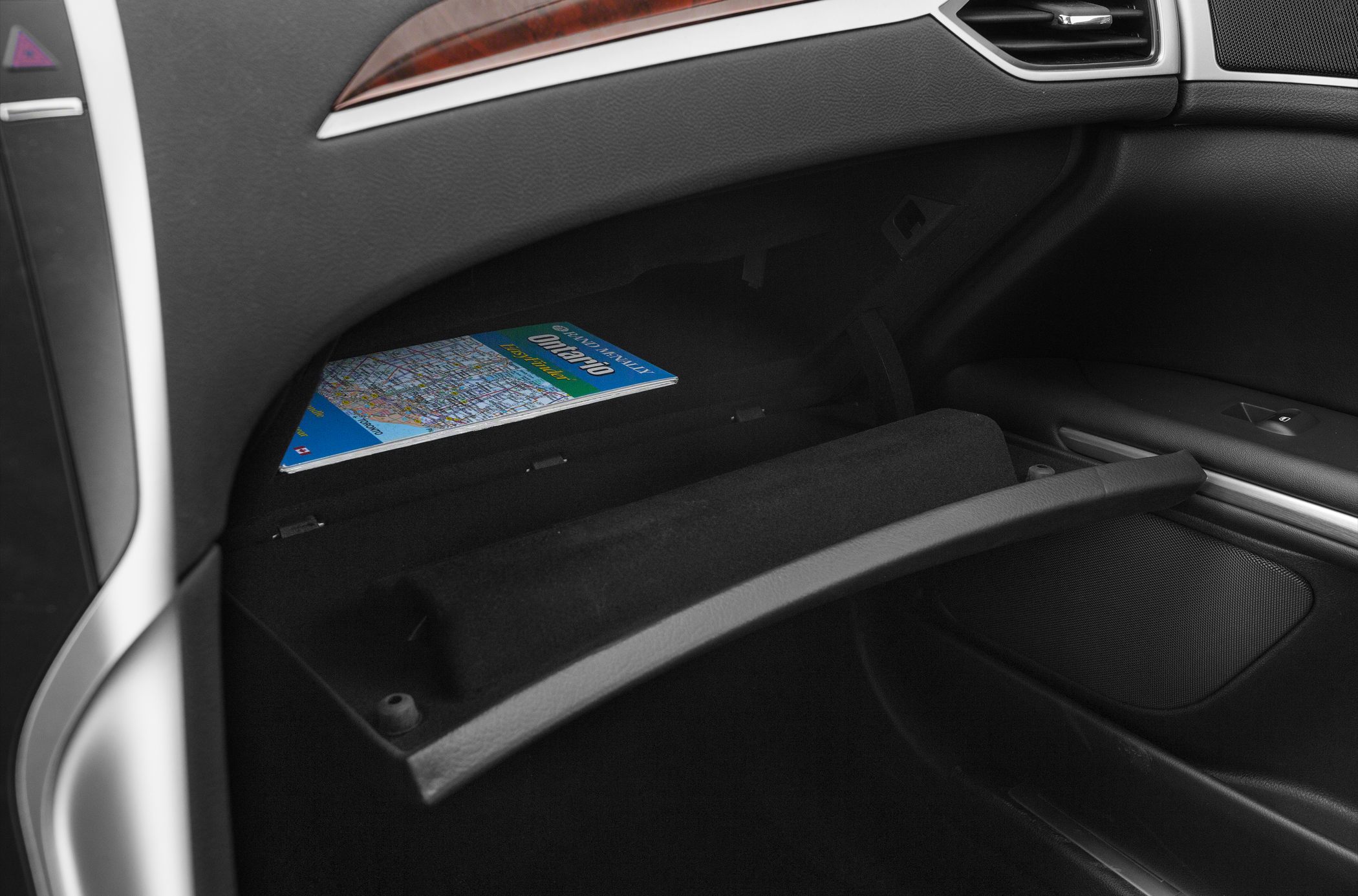Open glove compartment with map inside in car interior