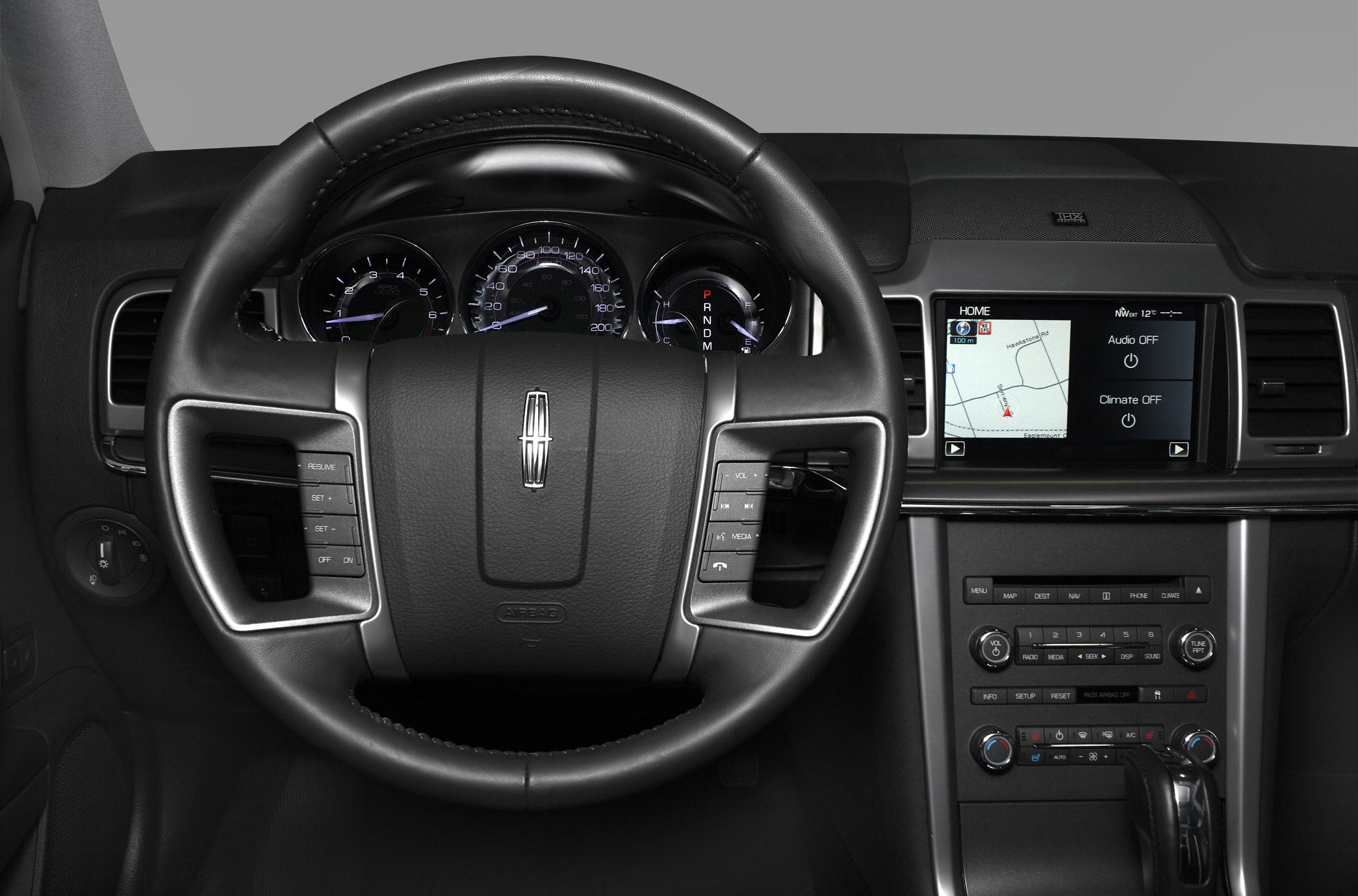Steering wheel with control buttons and dashboard featuring navigation display