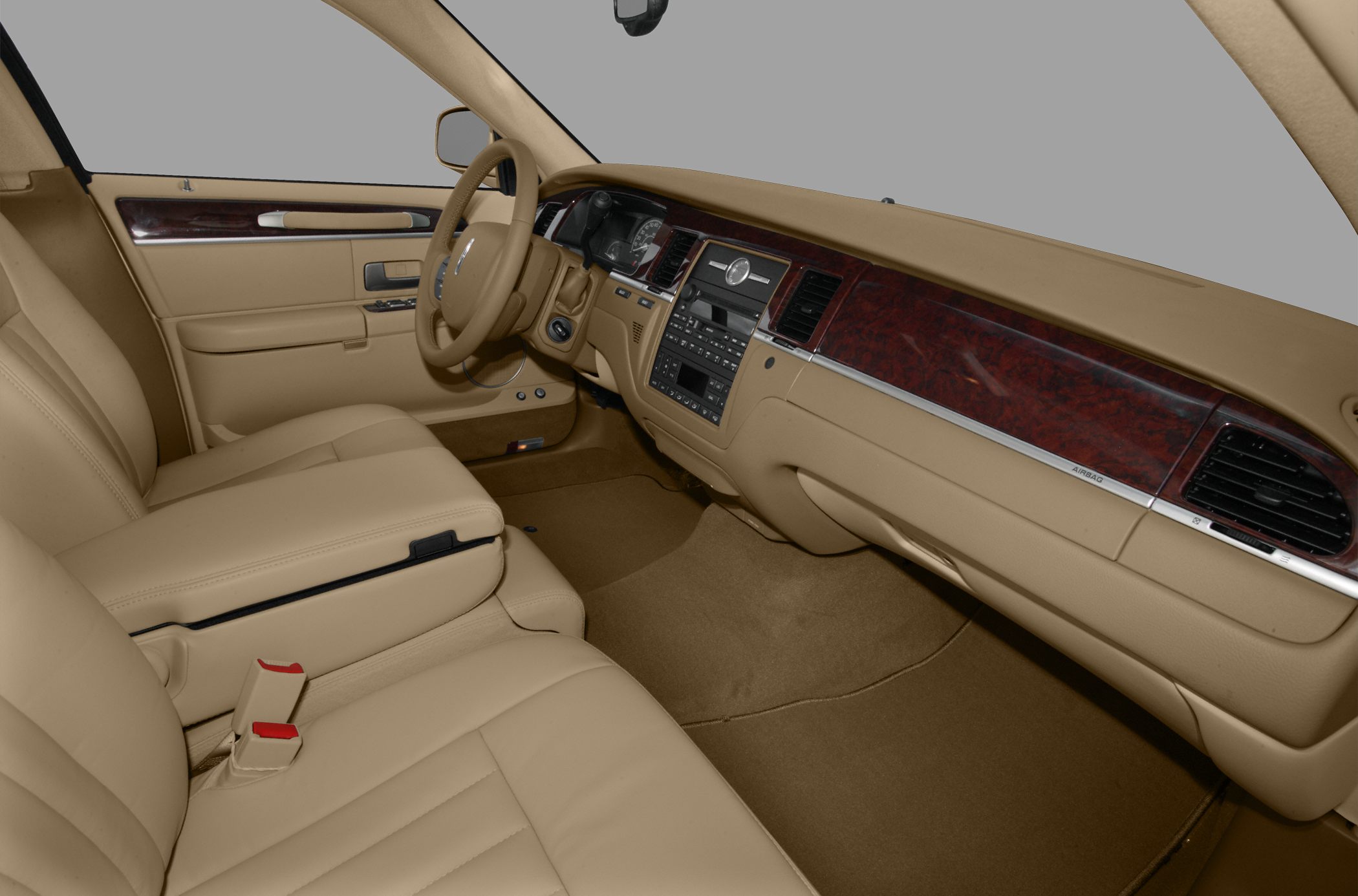 Tan leather front seats and wood-trimmed dashboard of luxury sedan