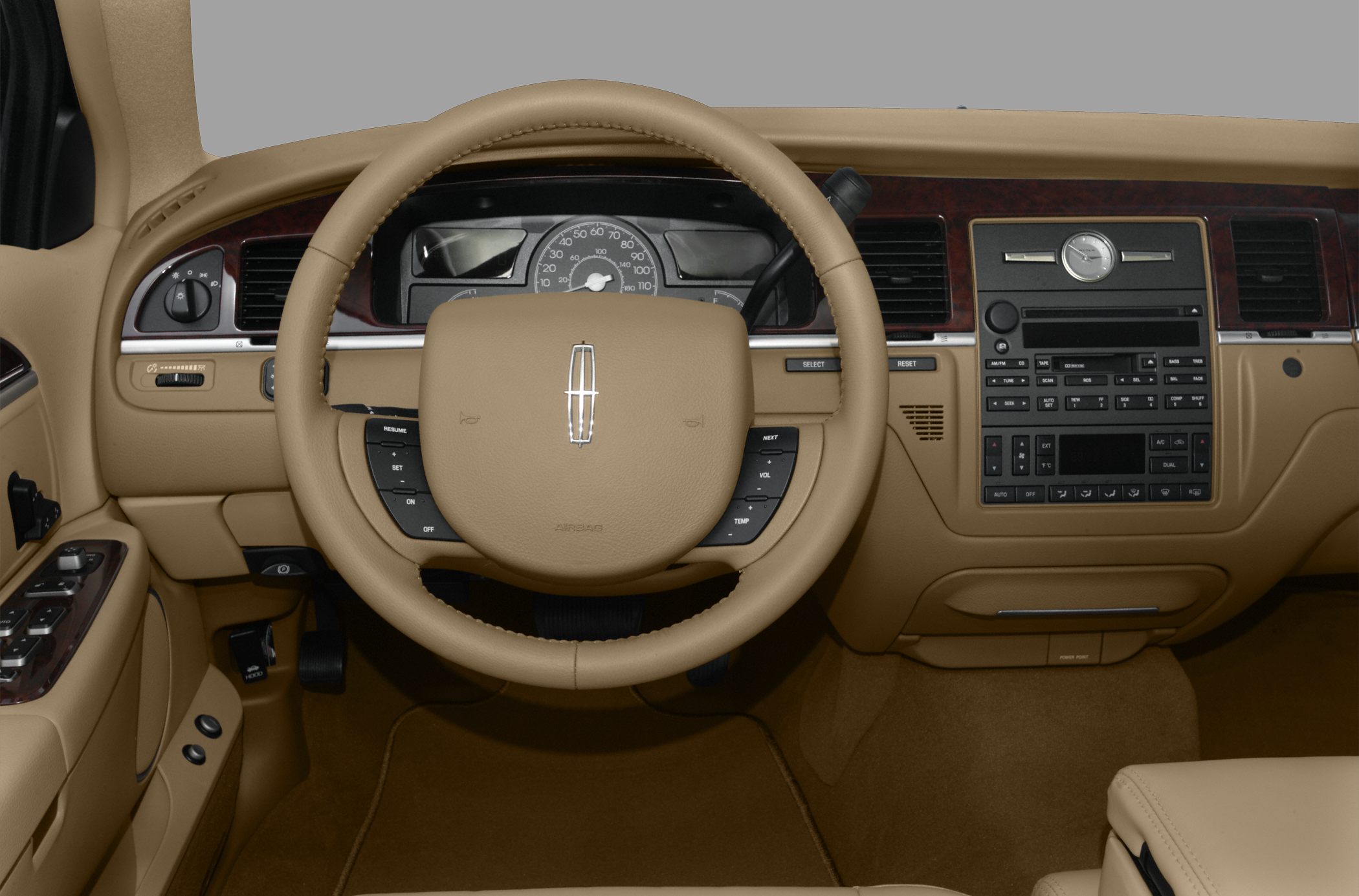 Tan leather steering wheel and wood-trimmed dashboard with analog clock
