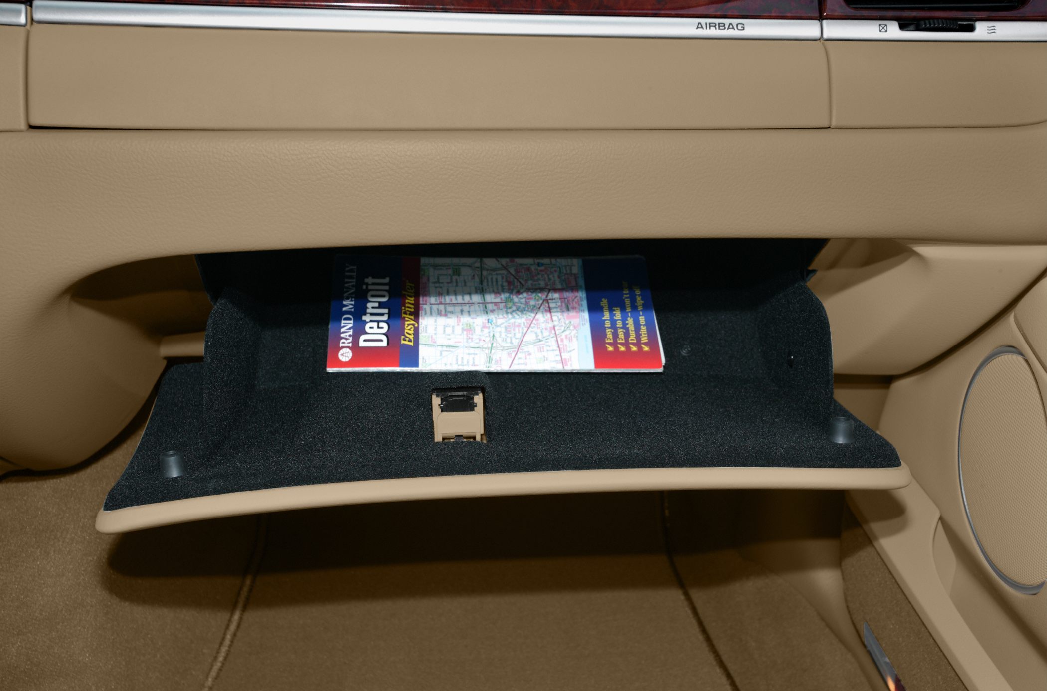Tan glove box with a map inside in a car interior