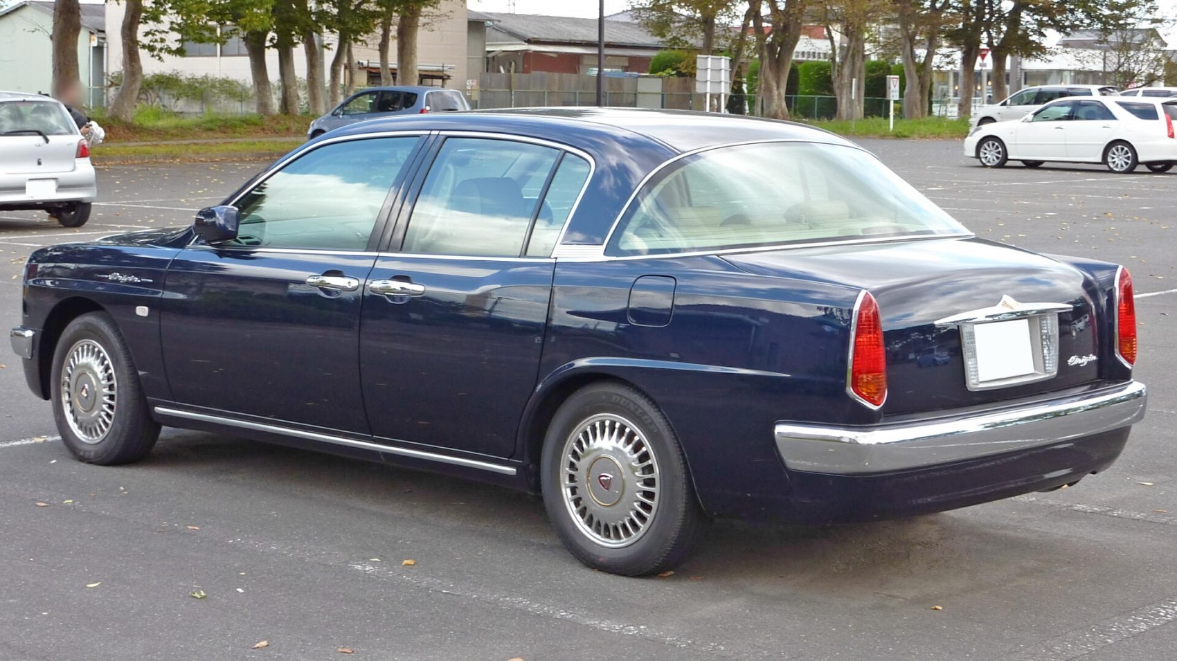 Retro-style dark blue sedan with chrome bumper and multi-spoke wheels