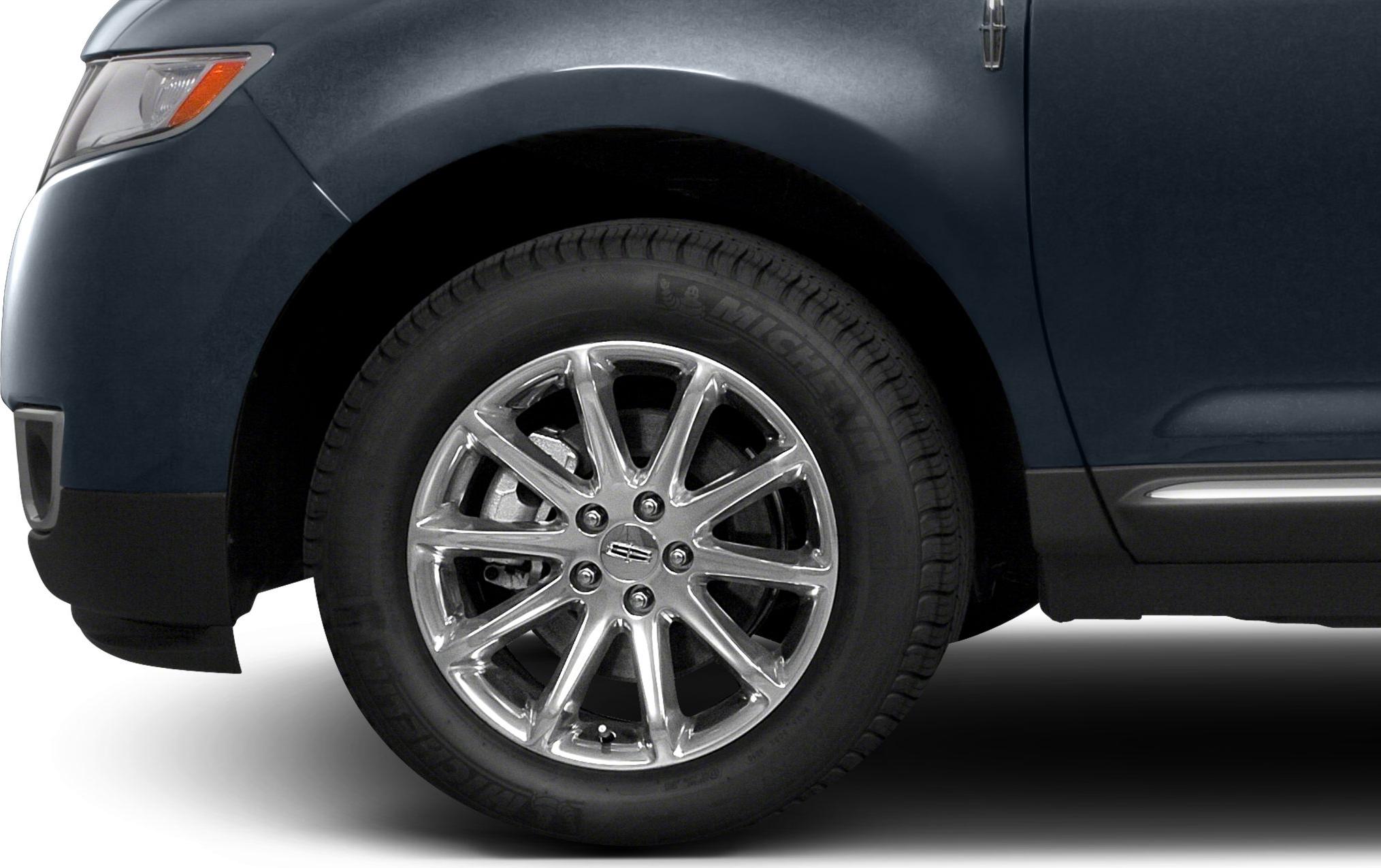 Close-up of chrome alloy front wheel and Michelin tire on vehicle