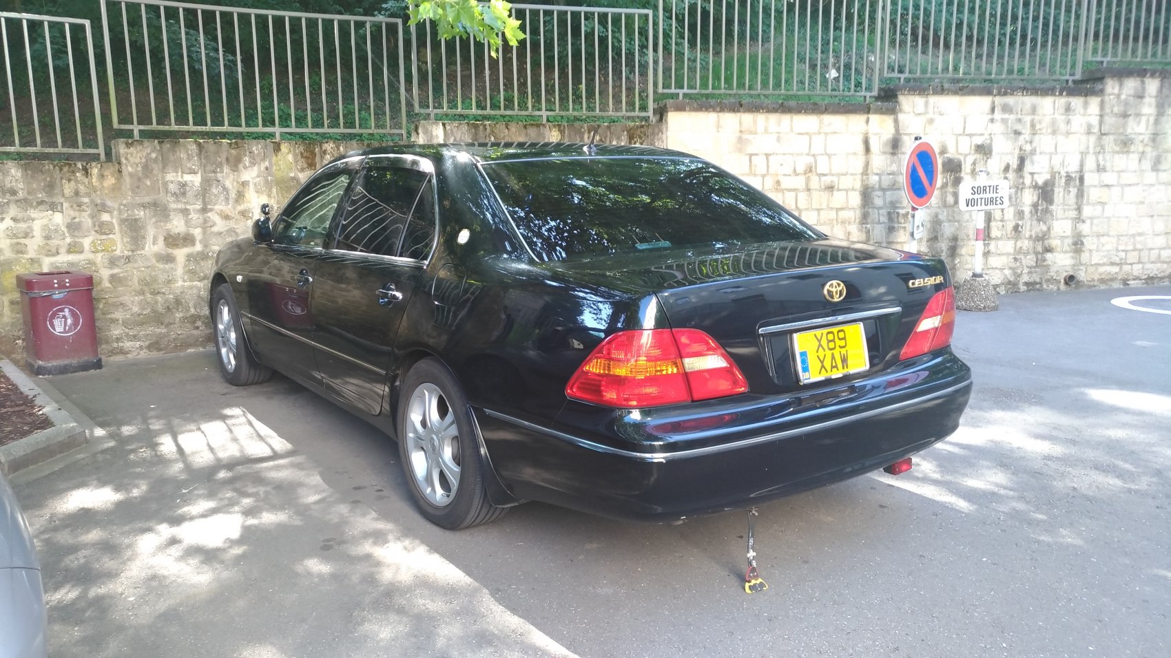 Rear view of a black luxury sedan with distinctive taillights and alloy wheels