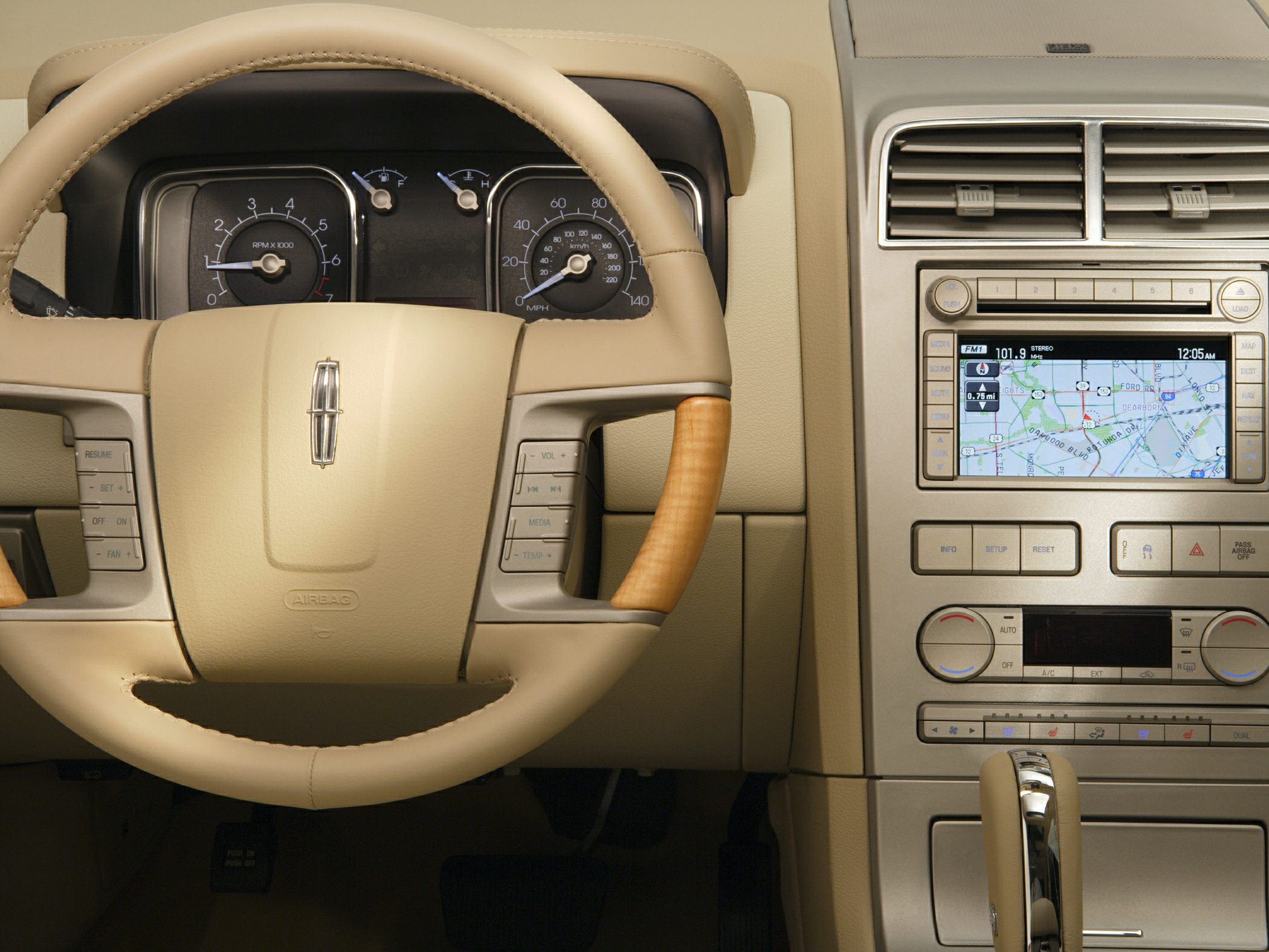 Leather steering wheel with wood accents and integrated navigation system display