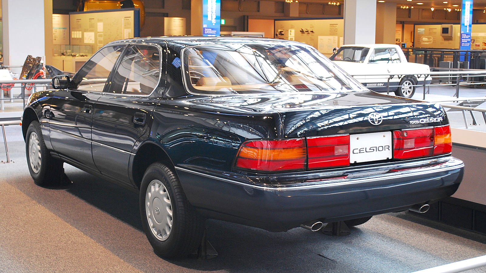 Rear view of a classic mid-1990s sedan with taillights and dual exhaust.