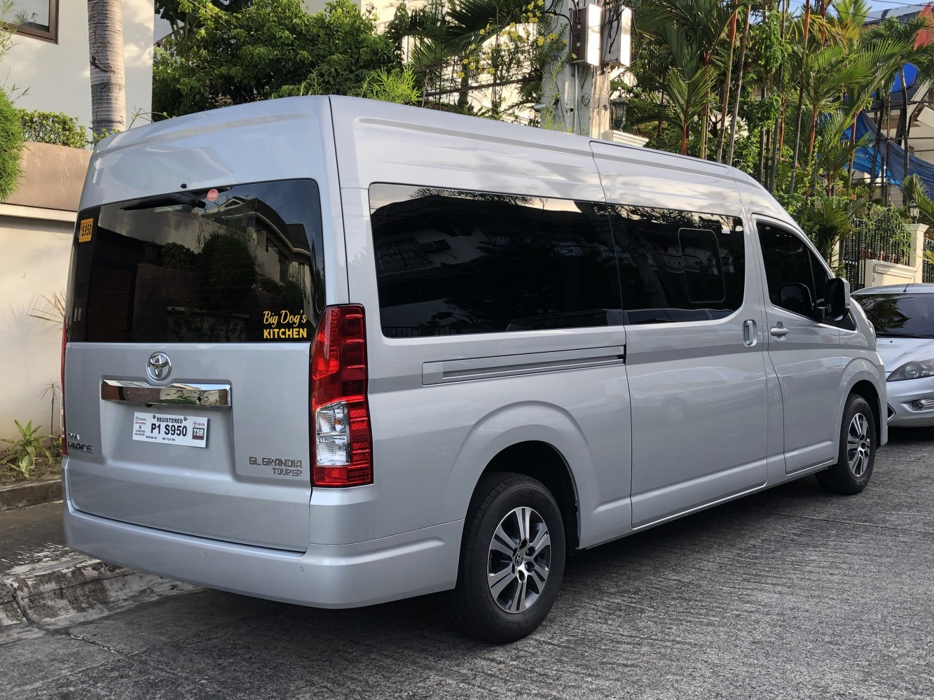 Rear and side view of a large passenger van with tinted windows and vertical taillights