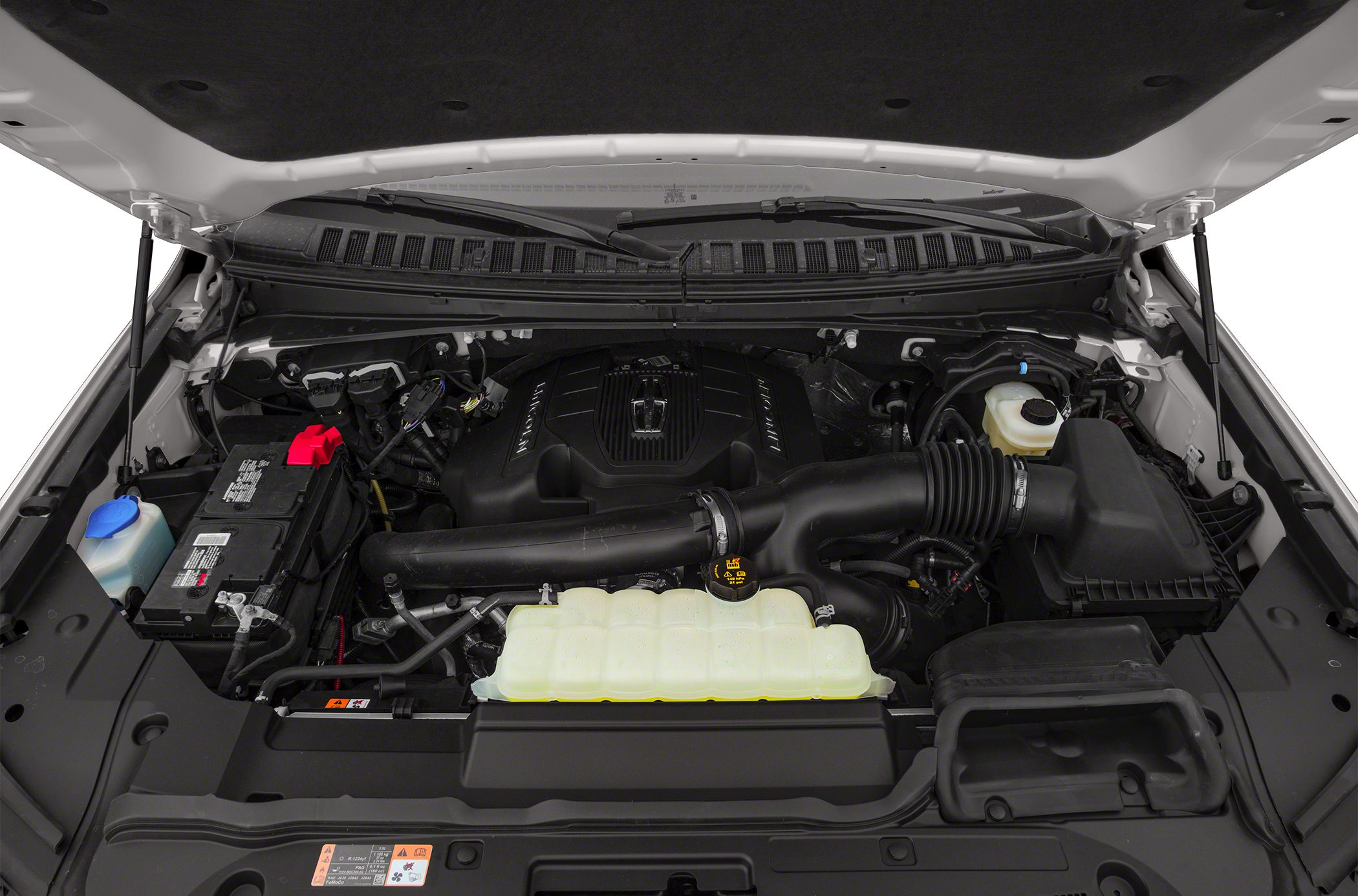 Engine bay with coolant reservoir, air intake pipe, and battery.