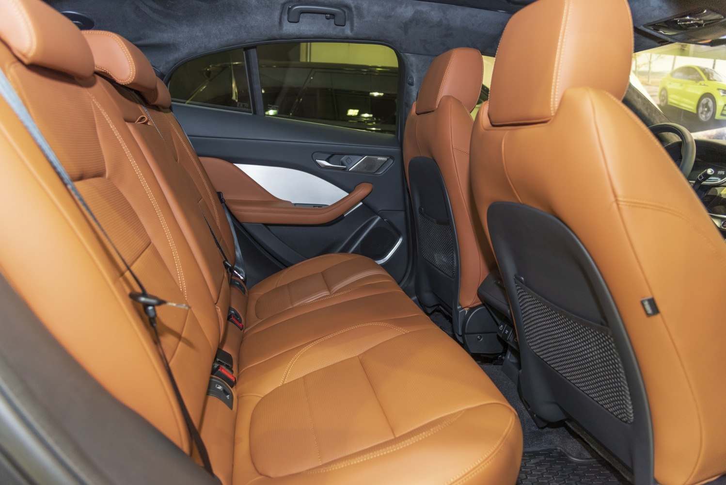 Brown leather rear seats with detailed stitching and ergonomic design.