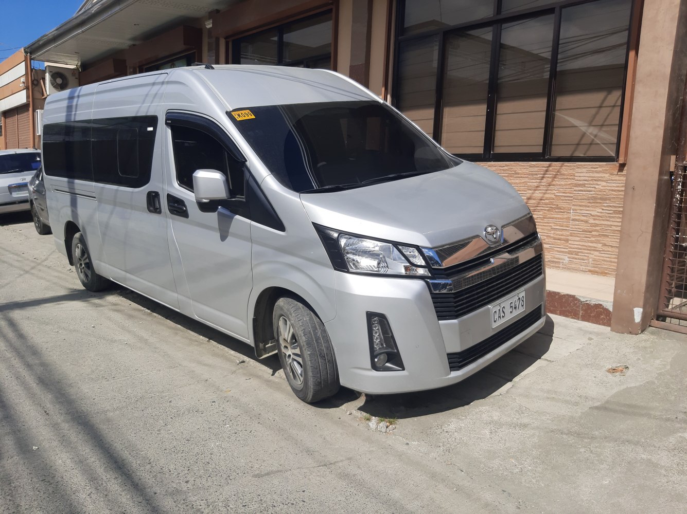 Silver high roof passenger van with wide side windows and modern front design