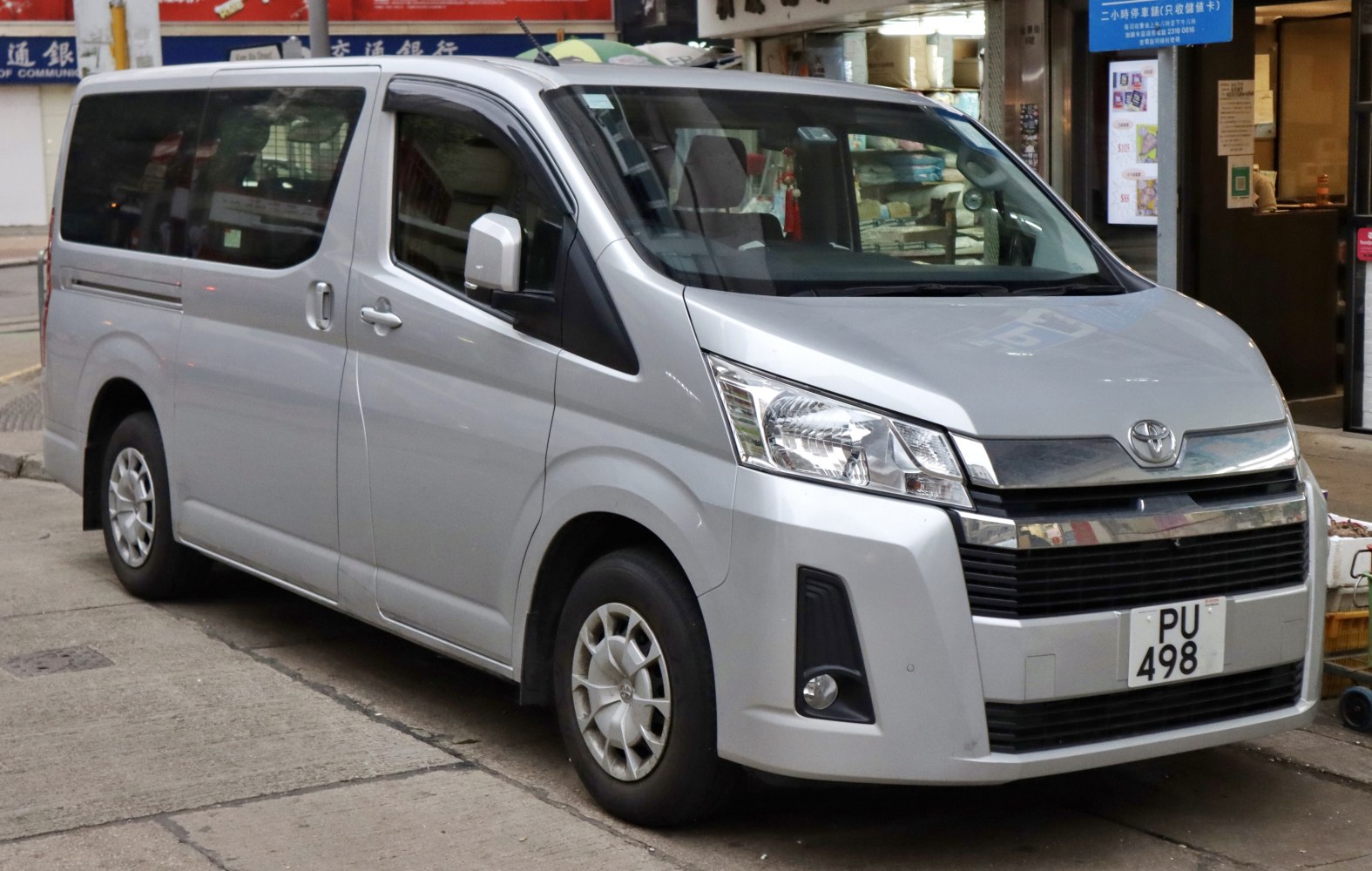 Silver passenger van with large windows and front-side view