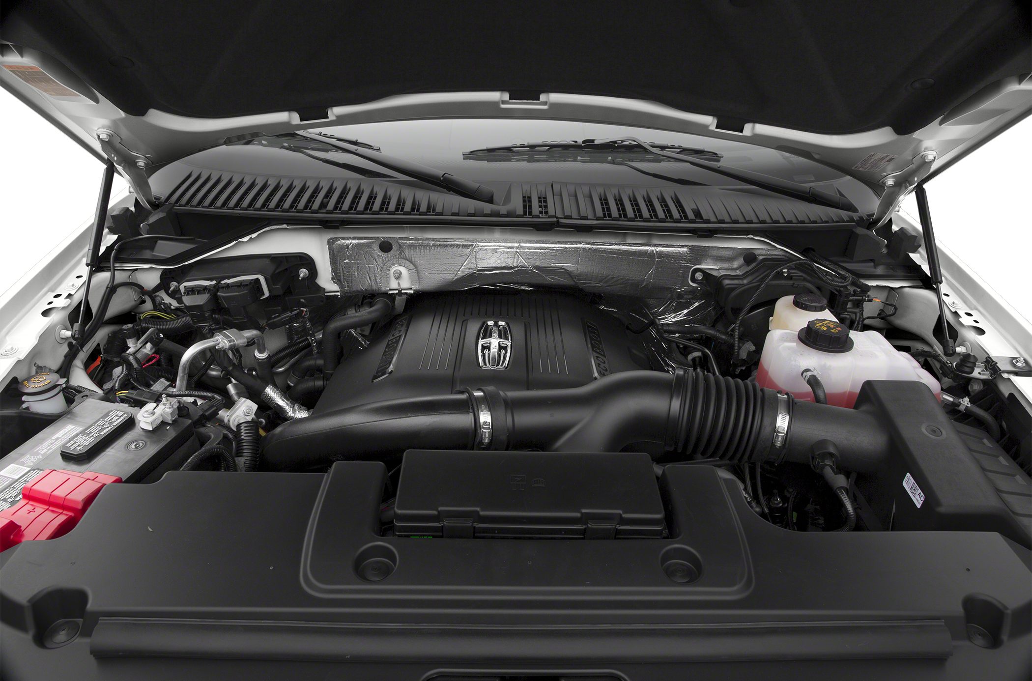 Engine bay of a luxury SUV with detailed components and engine cover.