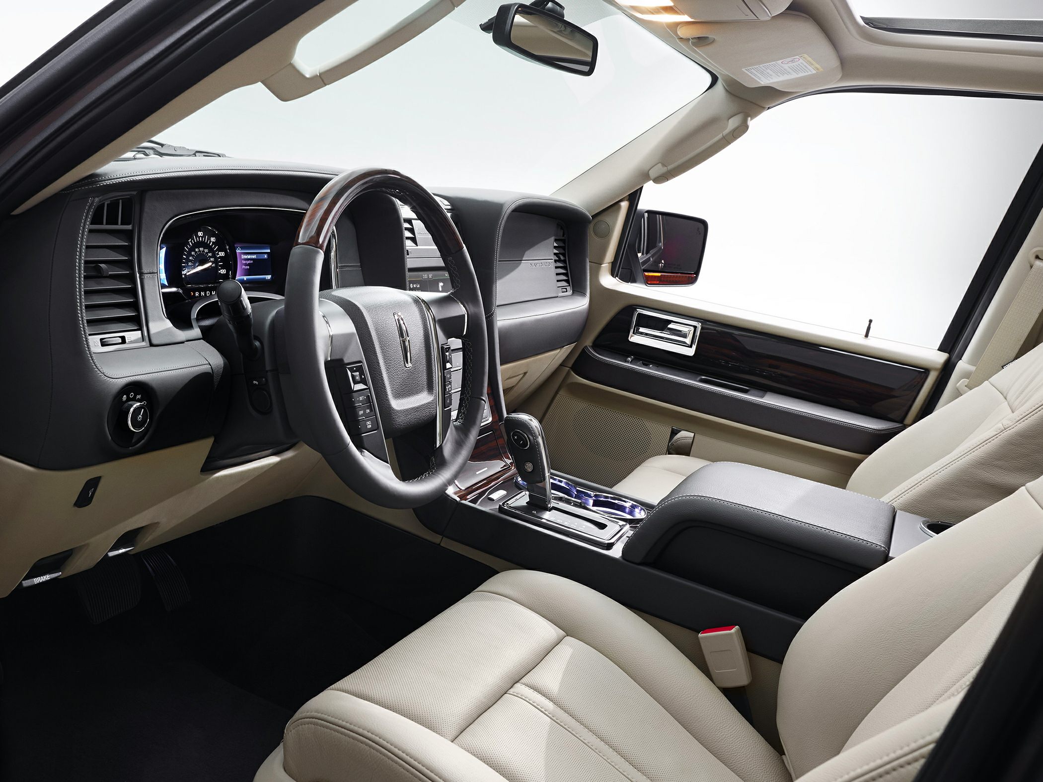 Modern SUV interior with wood-trimmed steering and beige leather seats