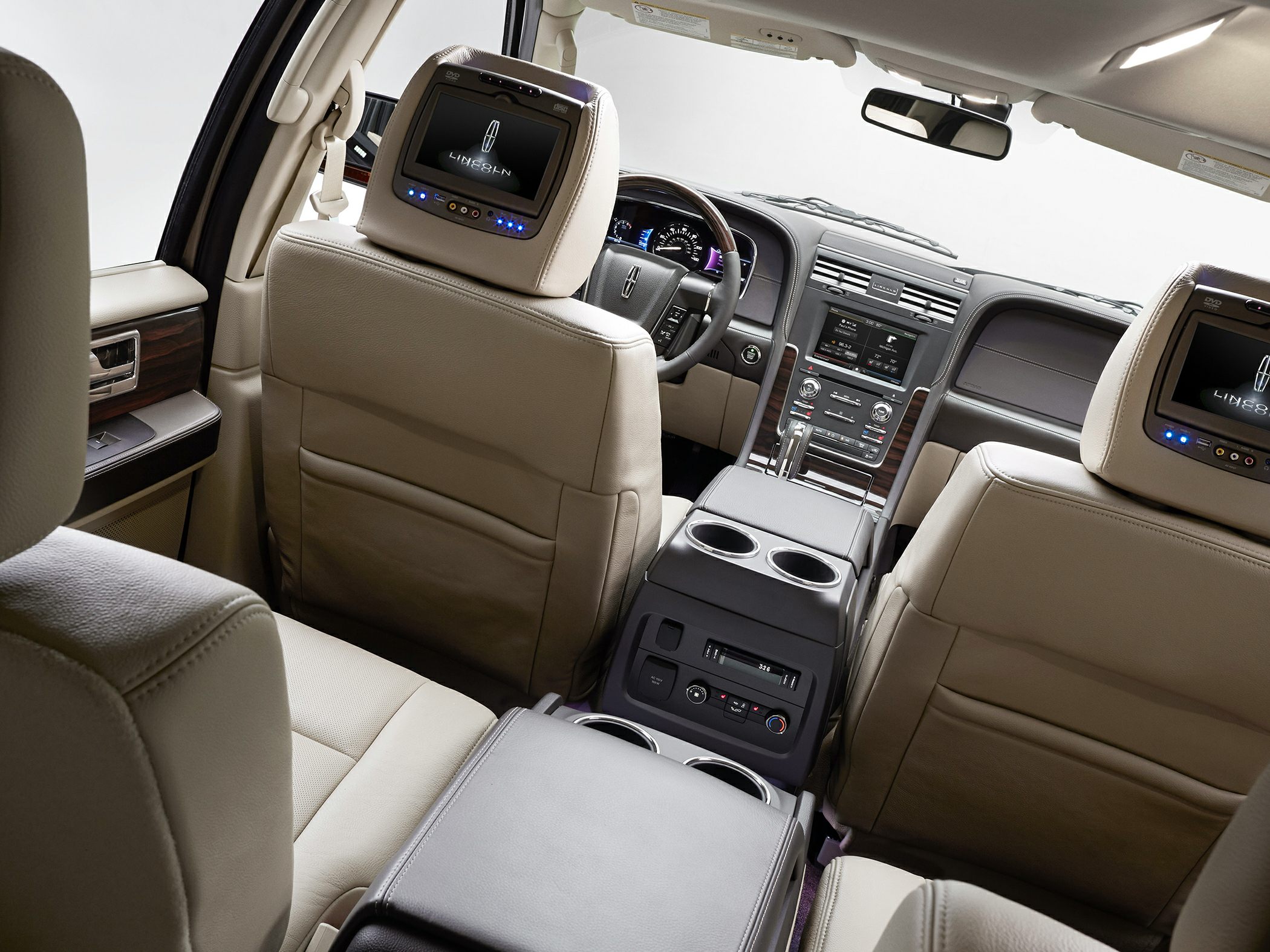 Dual rear entertainment screens and beige leather seats in luxury SUV interior