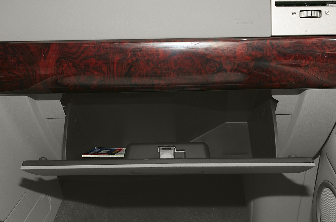 Open glove compartment with dark wood trim on dashboard interior