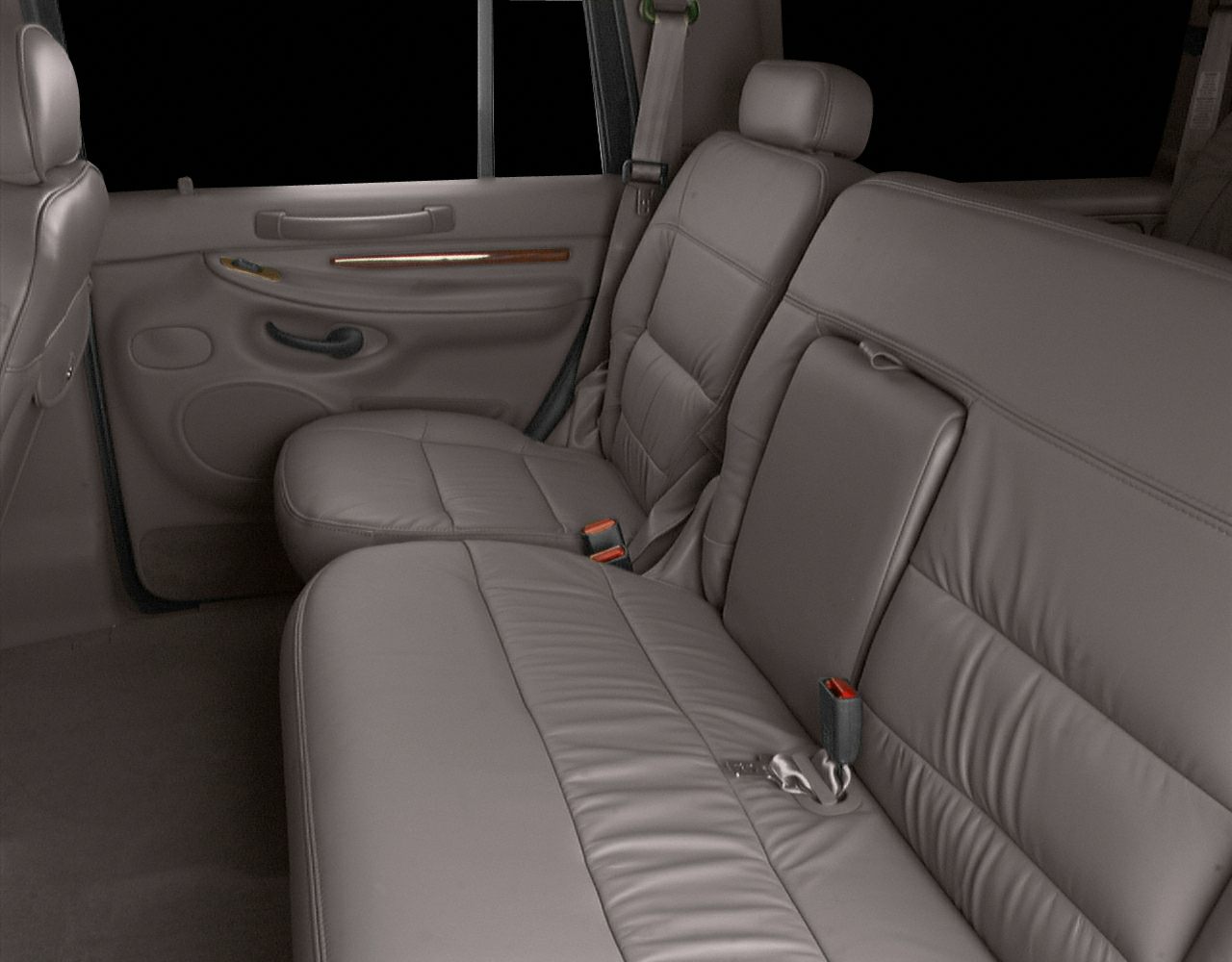 Leather rear seats with plush cushioning and wood trim on door panel