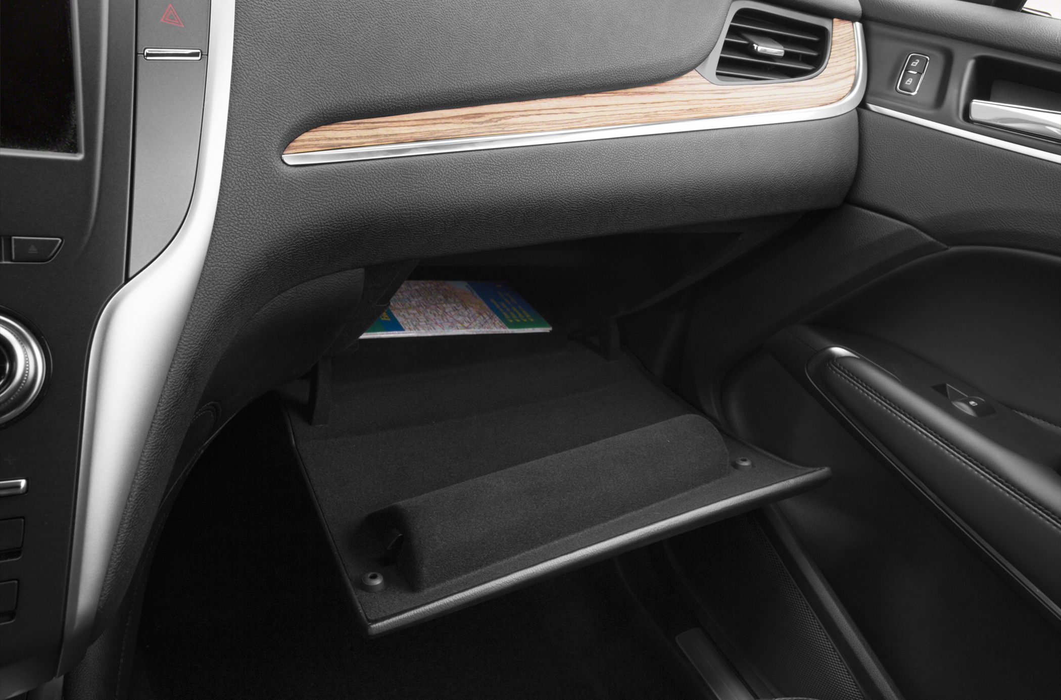 Open soft-lined glove compartment with wood trim dashboard and luxury interior details.