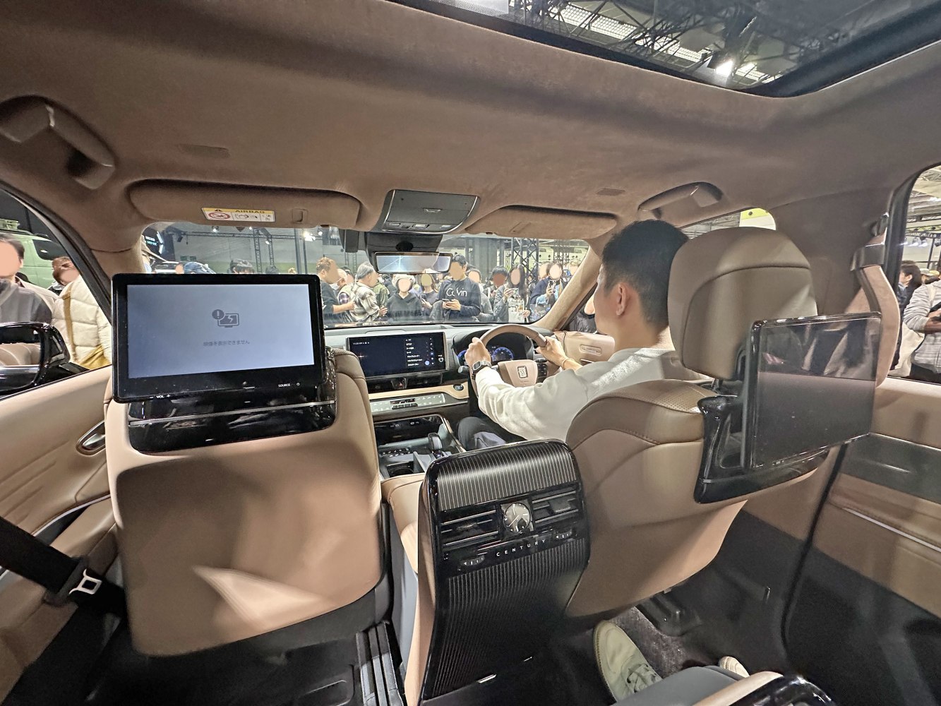 Rear entertainment screens, analog clock, beige leather cabin, panoramic sunroof